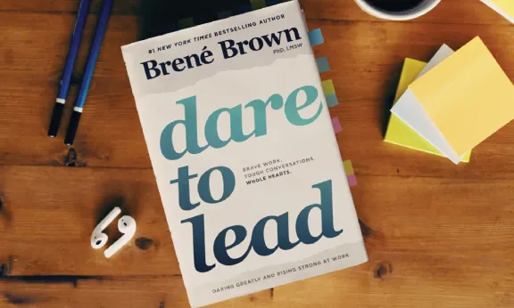 Dare to Lead book by Brené Brown on a wooden table