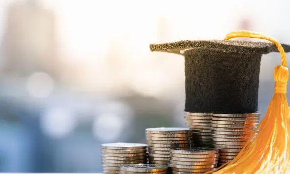 Graduation cap on top of stacked coins