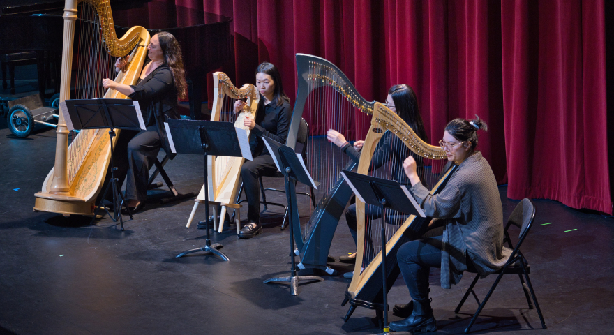 Four people playing harp
