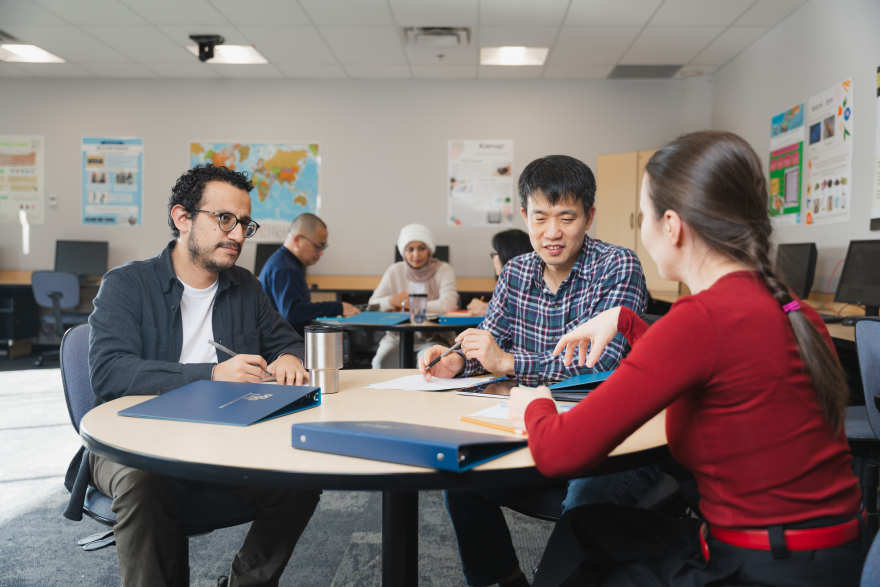 students discussing at a desk