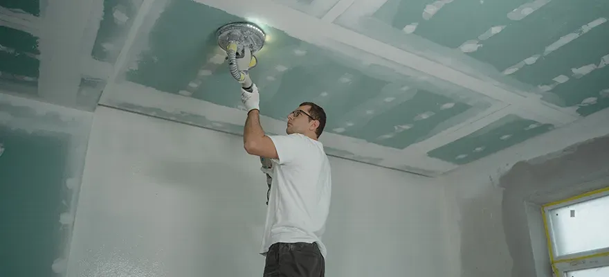 drywaller working on ceiling