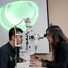 Student is testing a patient's eyes with a tonometer