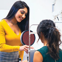 Student is testing a patient's eyesight with new opticianry technology