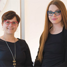 Students stand together smiling and wearing fashionable glasses