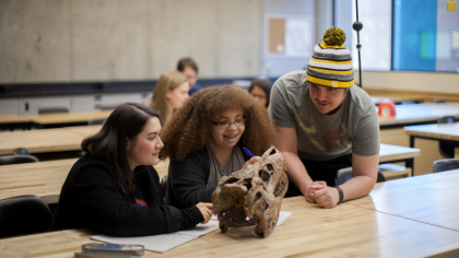 Students examining an archeology artifact
