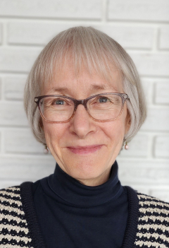 Photo of Ruth Enns with white brick wall in the background