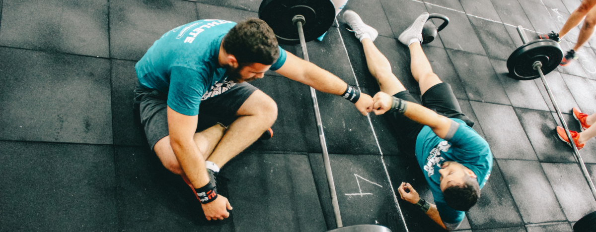 A personal trainer guiding a trainee in a gym