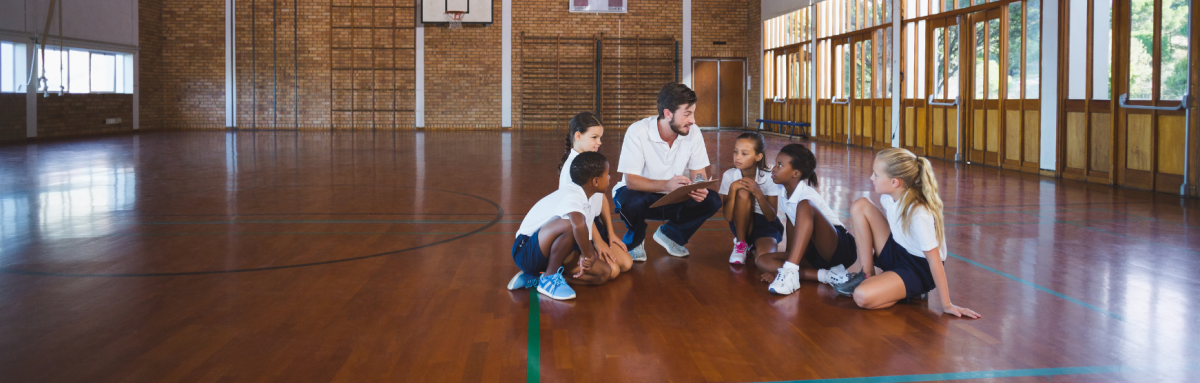 A physical education teacher teaching kids in the gym